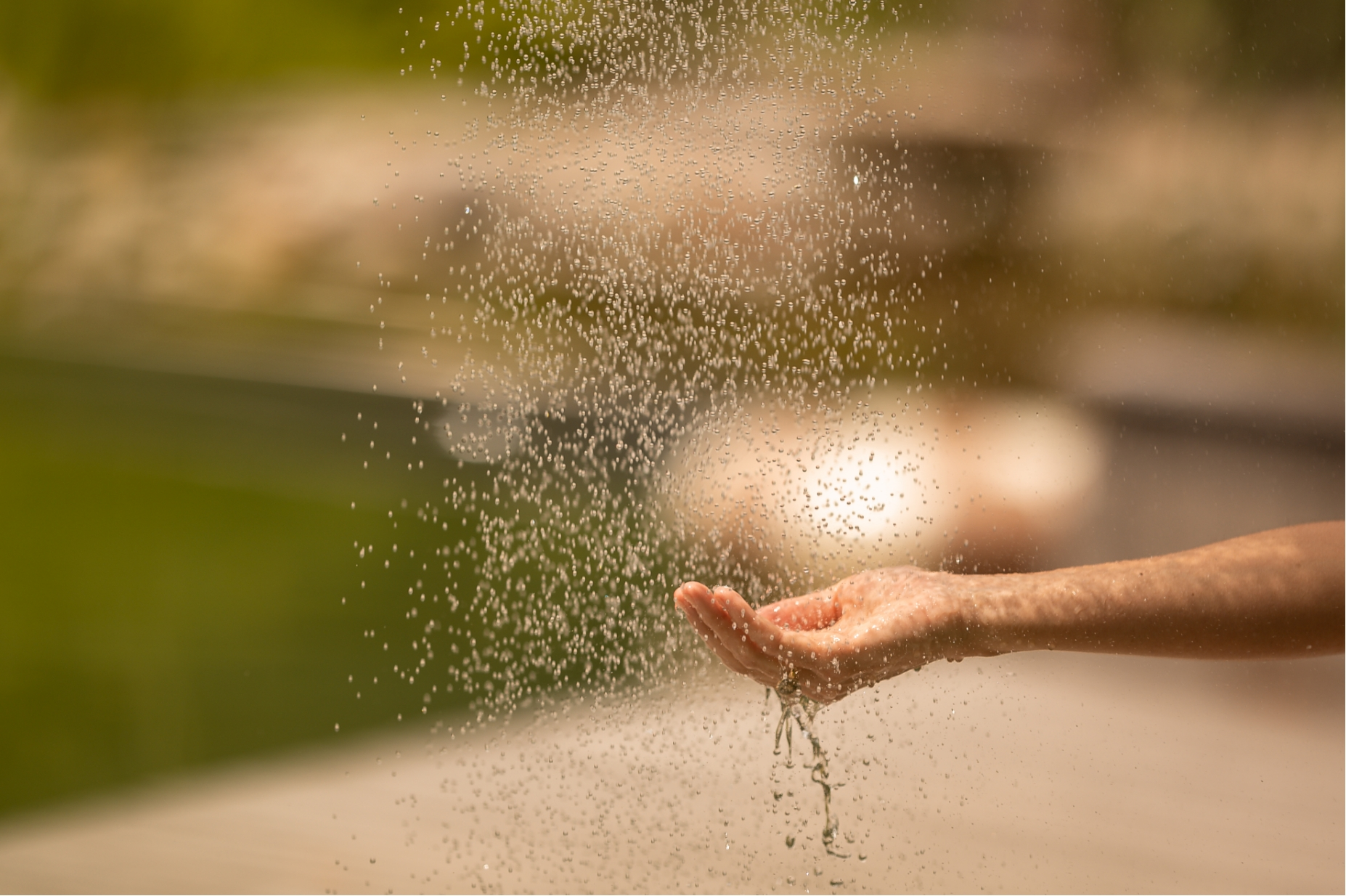 Erfrischung nach dem Sport – Wasserperlen auf der Hand im Stroblhof Wellnessbereich